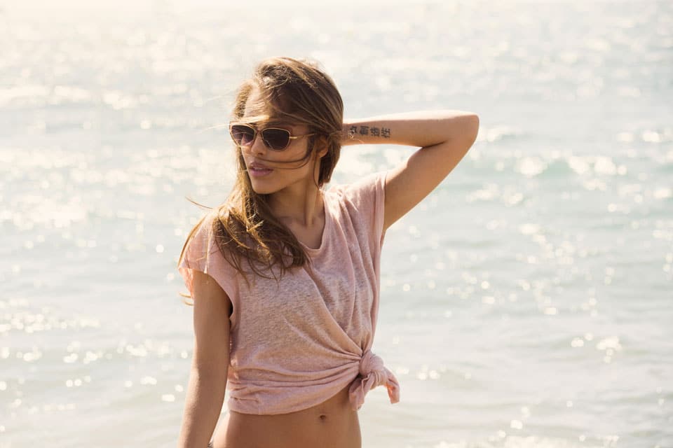 Frau am Meer mit Sonnenbrille.